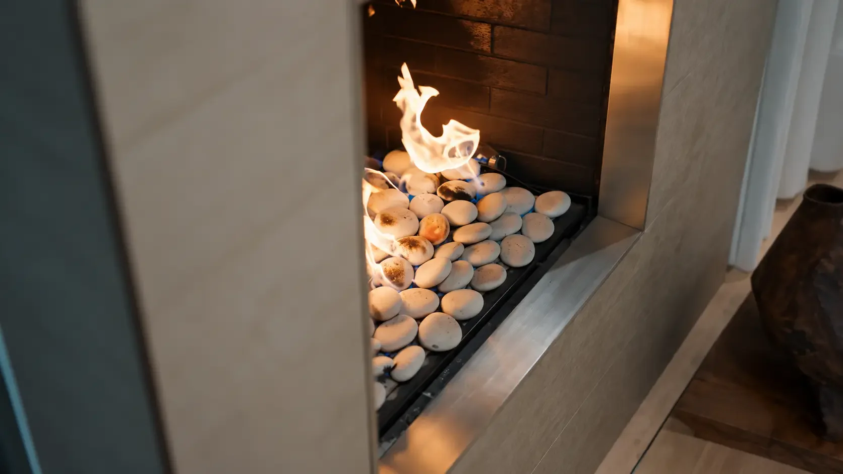 Detalle de una chimenea con llamas sobre piedras blancas